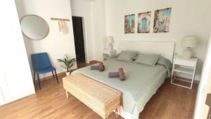 a bedroom with a bed and a blue chair at Sea La Vie Tabaiba - Piscina, Parking & Tenis in Tabaiba +40 photos