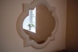 a mirror hanging on a wall with a window at Lambert Cottage - In the Heart of Stamford in Stamford