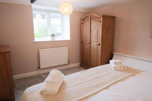 a bedroom with a bed with towels on it at Lambert Cottage - In the Heart of Stamford in Stamford