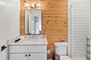een badkamer met een witte wastafel en een spiegel bij The Appalachian in Blowing Rock
