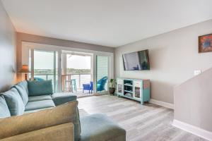 a living room with a couch and a tv at Folly Beach Retreat with Pool Access and River Views! in Folly Beach