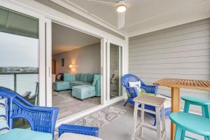 a porch with blue chairs and a table and a couch at Folly Beach Retreat with Pool Access and River Views! in Folly Beach