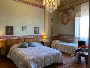 カルミニャーノにあるB&B La Roccaのベッドルーム1室(ベッド2台、シャンデリア付)