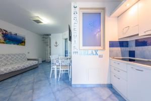 eine Küche und ein Wohnzimmer mit einem Sofa und einem Tisch in der Unterkunft Appartamento Relais sul mare 6 ospiti in Meta