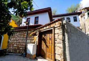 a house with a wooden door and a stone wall at Lionas Hotel Kaleici in Antalya