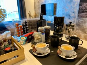 a table with two cups of coffee and a tray of food at Experience a Cozy Getaway Near Pulpit Rock in Strand