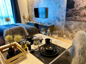 a dining table with a tray of dishes and wine glasses at Experience a Cozy Getaway Near Pulpit Rock in Strand