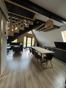 a living room with a table and chairs and a kitchen at CabanA Oscar in Borşa +22 photos