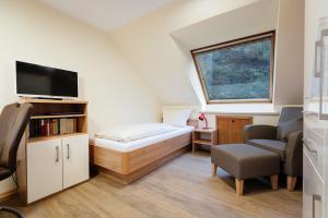 ein kleines Zimmer mit einem Bett und einem Stuhl in der Unterkunft Haus Frier in Helgoland