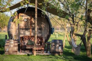 cenador con sofá frente a un árbol en Tiny Wineyhouse 3 en Zennewijnen