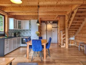 ワプシェ・ニジネにあるLK Resort Łapsze domy z prywatną balią i saunąのキッチン(木製テーブル、青い椅子付)