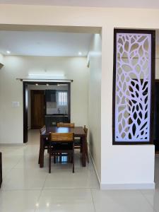 jadalnia ze stołem i białą ścianą w obiekcie Oryx Residences - Luxury Serviced Apartments w mieście Mysuru
