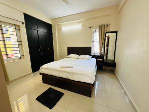 a bedroom with a bed and a mirror in it at Oryx Residences - Luxury Serviced Apartments in Mysore