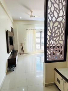 a living room with a tv and a large window at Oryx Residences - Luxury Serviced Apartments in Mysore