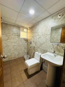 a bathroom with a toilet and a sink at Oryx Residences - Luxury Serviced Apartments in Mysore