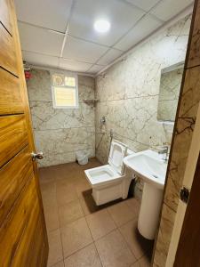 La salle de bains est pourvue de toilettes et d'un lavabo. dans l'établissement Oryx Residences - Luxury Serviced Apartments, à Mysore