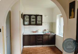 uma cozinha com armários castanhos e um balcão branco em Chata MIMONKA em Dedinky