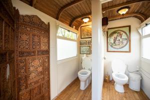 a bathroom with a toilet and a wooden door at Tiny Wineyhouse 3 in Zennewijnen