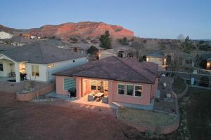 an aerial view of a house with a mountain in the background at 3x3 Sanctuary at Kanab - New West Properties in Kanab