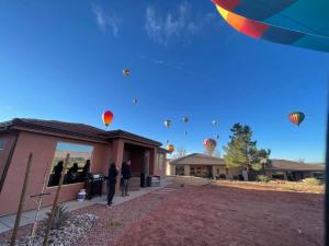 a bunch of hot air balloons flying in the sky at 3x3 Sanctuary at Kanab - New West Properties in Kanab +45 photos