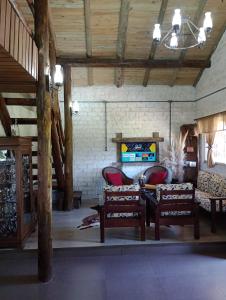 sala de estar con 2 sillas y mesa en Casa aconchegante em meio a natureza, en Caxias do Sul