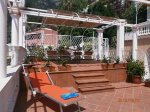 
a patio area with chairs, tables, and umbrellas at Little Flower in Positano
