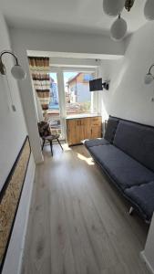 salon z kanapą i dużym oknem w obiekcie RENESANS we Władysławowie