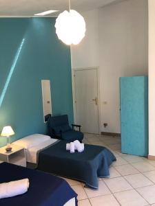 Habitación con 2 camas y pared azul en La casetta della zia Nina, en Santo Stefano di Camastra