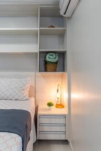 a bedroom with a bed and a lamp on a night stand at PALMAS EXPERIENCE - FLAT PÔR DO SOL, vista panorâmica, melhor localização in Palmas