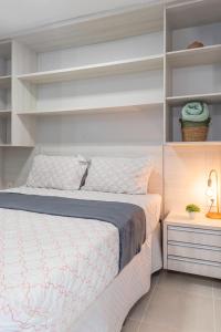 a bedroom with a bed with white shelves at PALMAS EXPERIENCE - FLAT PÔR DO SOL, vista panorâmica, melhor localização in Palmas