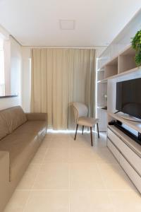 sala de estar con sofá y TV en PALMAS EXPERIENCE - FLAT PÔR DO SOL, vista panorâmica, melhor localização, en Palmas