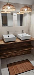 zwei Waschbecken im Bad mit zwei Spiegeln in der Unterkunft Bohême Carib & Massage - Un Goût De Paradis ! in Deshaies