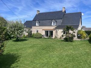 ein großes weißes Haus mit einem großen Hof in der Unterkunft Villa CHESTER 9 km d'Omaha Beach in Trévières