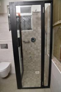 a shower with a glass door in a bathroom at Lisa's 4 bedroom villa in Kampala