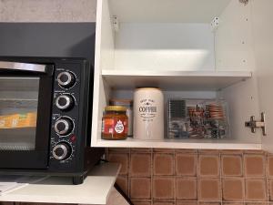 a cupboard with spices and a microwave next to a kitchen at Apart am Listersee in Meinerzhagen