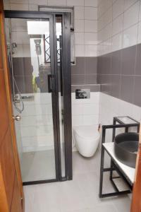 een badkamer met een douche en een toilet bij Lisa's 4 bedroom villa in Kampala