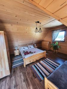 a bedroom with a bed in a wooden cabin at Domki Na Grapie - z widokiem na Tatry in PyzÃ³wka