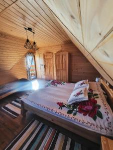 a bedroom with a bed in a wooden room at Domki Na Grapie - z widokiem na Tatry in PyzÃ³wka