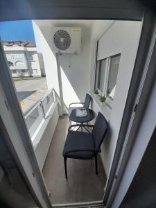 巴尼亚科维利亚查Апартман Љесковац的小阳台,配有桌子和椅子