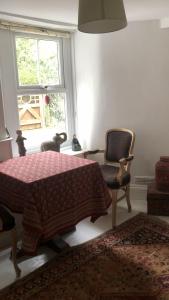 a bedroom with a bed and a chair and a window at Komorebi Healing House in Dawlish