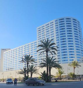 un grand bâtiment avec des palmiers devant lui dans l'établissement Luxury apartment near TGV station and the beach, à Tanger