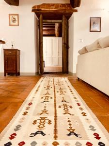 a living room with a rug in front of a door at Casa il Cassero in Castiglion Fiorentino +12 photos