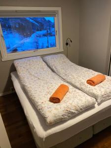 two beds sitting next to a window with towels on them at Sokndal - Cozy vacation home in peaceful surroundings in Ålgård