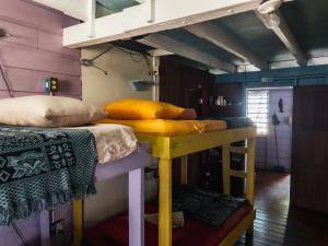 a bunk bed with pillows on it in a room at Anda Di Hows Hostel in Placencia