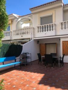 een huis met een patio met stoelen en een tafel bij Casa adosada Playa de Gandia (2 plantas) in Playa de Gandia