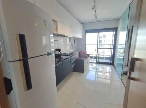 een keuken met een witte koelkast in de kamer bij Conforto próximo ao Farol in Salvador