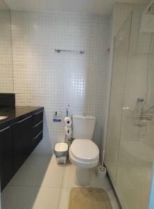 een badkamer met toilet en glazen douche bij Conforto próximo ao Farol in Salvador
