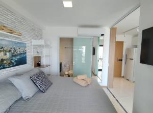 een slaapkamer met een groot bed en een televisie bij Conforto próximo ao Farol in Salvador +7 foto's