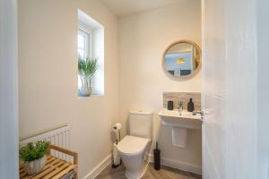 a bathroom with a toilet and a sink and a mirror at Huge Weekly & Monthly Savings - Free Parking - Wi-Fi & Netflix in Gloucester +23 photos