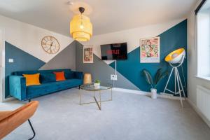 a living room with a blue couch and a table at Huge Weekly & Monthly Savings - Free Parking - Wi-Fi & Netflix in Gloucester
